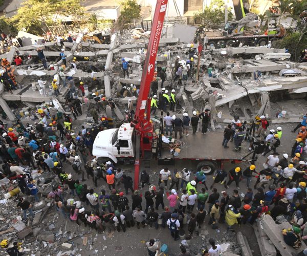 Rescuers and volunteers search for survivors amid the rubble of a collapsed building after an earthquake in Cali, Colombia on August 11, 2026. Colombian volunteers and rescuers cleared rubble with their bare hands to search for survivors early on August 11 after the country's strongest earthquake in a decade killed at least 169 people and smashed dozens of buildings. (Photo by JOAQUIN SARMIENTO / AFP)