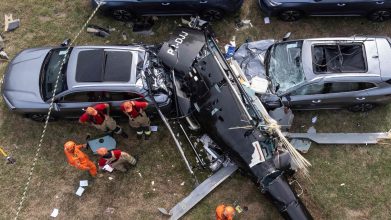 An aerial view shows firefighters working at the site of a helicopter crash in the Recreio dos Bandeirantes neighbourhood in Rio de Janeiro, Brazil, on June 14, 2026. At least six people died in Brazil on June 14 after two helicopters crashed in western Rio de Janeiro, after a suspected mid-air collision, firefighters said. (Photo by Tercio TEIXEIRA / AFP)