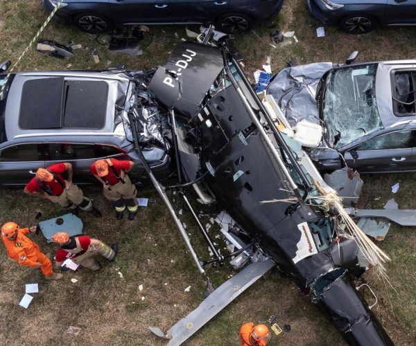 An aerial view shows firefighters working at the site of a helicopter crash in the Recreio dos Bandeirantes neighbourhood in Rio de Janeiro, Brazil, on June 14, 2026. At least six people died in Brazil on June 14 after two helicopters crashed in western Rio de Janeiro, after a suspected mid-air collision, firefighters said. (Photo by Tercio TEIXEIRA / AFP)